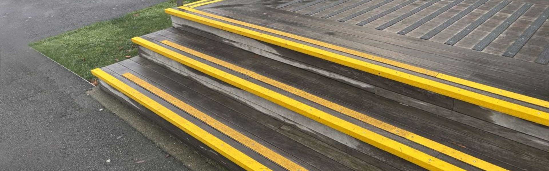GRP stair nosings and decking strips installed on a staircase and walkway to enhance safety and reduce slips